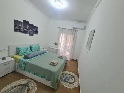 a white bedroom with a bed and a window at Luxury apartment in Sepolia in Athens