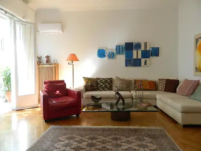 a living room with a couch and a red chair at Elegant 3BD apartment in Kolonaki in Athens