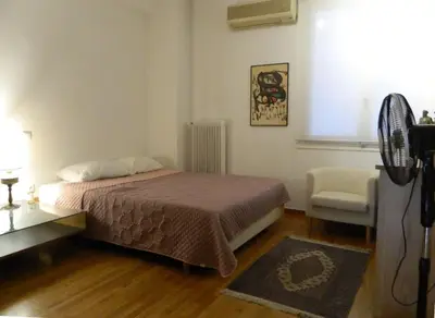 a small bedroom with a bed and a chair at Elegant 3BD apartment in Kolonaki in Athens