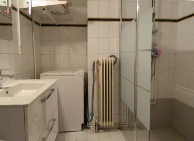 a bathroom with a radiator next to a sink and a shower at Elegant 3BD apartment in Kolonaki in Athens