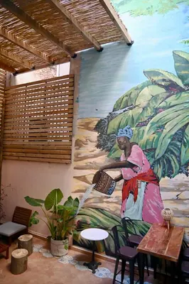 a mural on the side of a building with a woman pouring water at Baloo Hostel in Athens