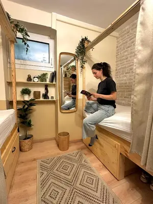 a woman sitting on a bed in a tiny house at Baloo Hostel in Athens