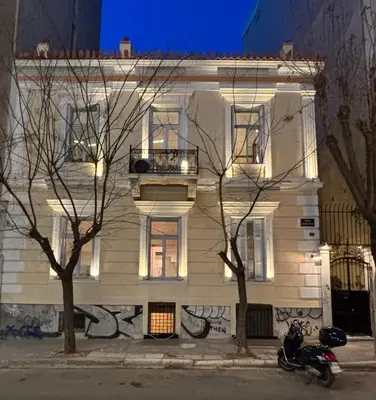 a white building with a motorcycle parked in front of it at Baloo Hostel in Athens