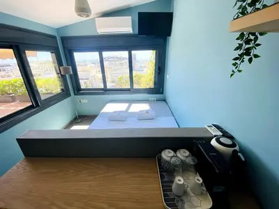 a small room with a bed and two windows at 200Mbps Wifi - Penthouse With Acropolis View in Athens