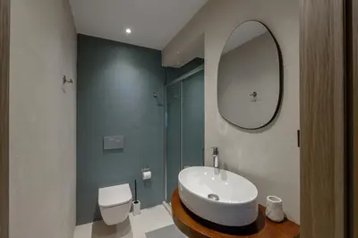 a bathroom with a sink and a toilet and a mirror at Galio Suites Airport by Airstay in Spáta