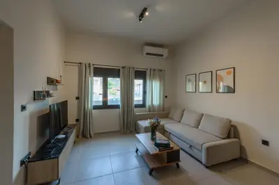 a living room with a couch and a tv at Galio Suites Airport by Airstay in Spáta