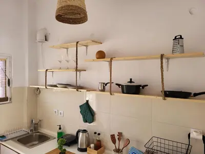 a kitchen with wooden shelves and a sink at Viva La Veranda Apartment in Central Athens in Athens