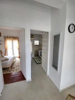 a living room with a bed and a clock on a wall at Viva La Veranda Apartment in Central Athens in Athens