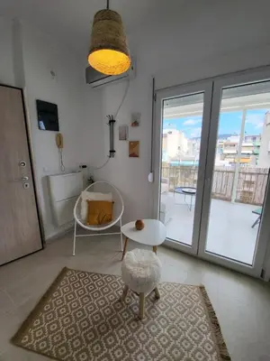 a living room with a table and a chair at Viva La Veranda Apartment in Central Athens in Athens