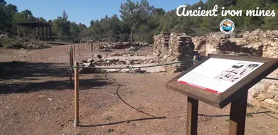 a sign in the middle of a field with ruins at Patroclos SeaView in Sounio
