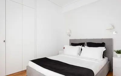 a white bedroom with a large bed with white pillows at Acropolis Urban Life in Athens