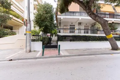 a tree on the side of a street in front of a building at AIOLOS LUXURY alimos market apartment 2 near the sea in Athens