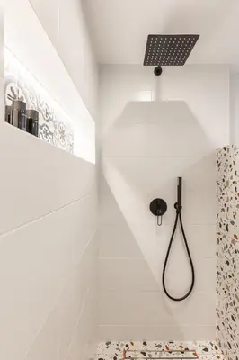 a white bathroom with a shower with a black shower head at Ermoo Athens Modern Living in Athens