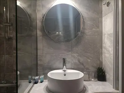 a bathroom with a white sink and a mirror at Kallimarmaro Refuge in Athens