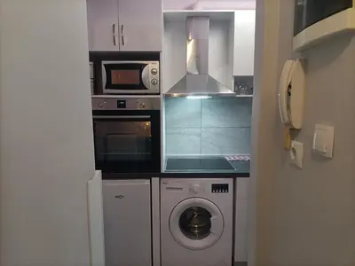 a kitchen with a washing machine and a microwave at Kallimarmaro Refuge in Athens