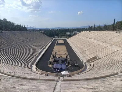 an empty stadium with a truck in the middle at Kallimarmaro Refuge in Athens