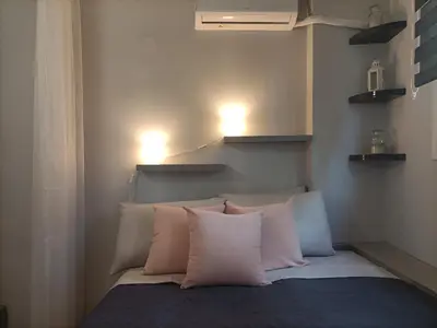 a bedroom with a bed with pillows and two lights at Kallimarmaro Refuge in Athens