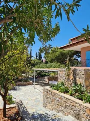 a garden with a stone walkway and a stone wall at Villa-Agave , by the sea in Porto-Rafti outside Athens in Porto Rafti