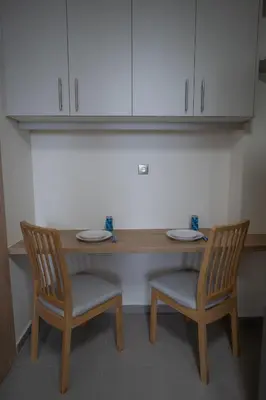 a wooden table and two chairs with plates on it at Max Blue apartment, a stay like no other in Piraeus