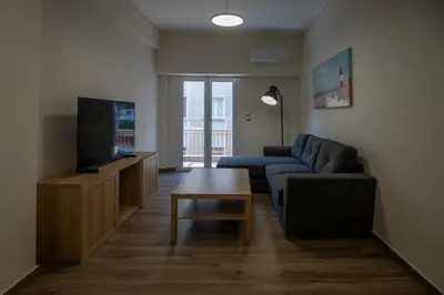 a living room with a couch and a tv at Max Blue apartment, a stay like no other in Piraeus