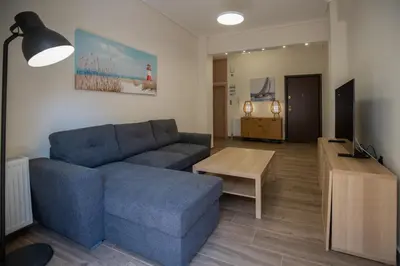a living room with a blue couch and a table at Max Blue apartment, a stay like no other in Piraeus