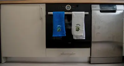 a kitchen oven with two towels on the door at Max Blue apartment, a stay like no other in Piraeus
