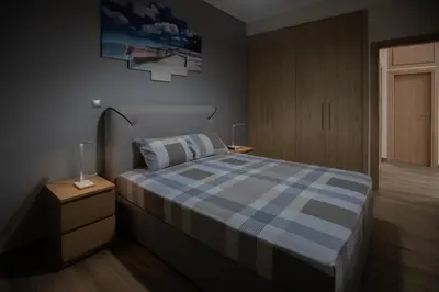 a bedroom with a bed with a blue checkered blanket at Max Blue apartment, a stay like no other in Piraeus