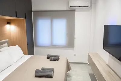 a bedroom with a bed and a flat screen tv at L apartment2 in Athens