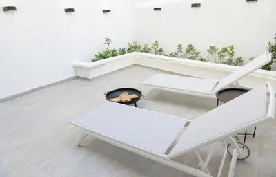 a room with two white chairs and a fire place at L apartment2 in Athens