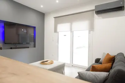 a living room with a couch and a tv at L apartment2 in Athens