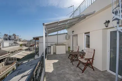 a patio with a table and chairs on a balcony at Marina Zeas Skydeck in Piraeus