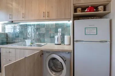 a kitchen with a refrigerator and a washing machine at Marina Zeas Skydeck in Piraeus