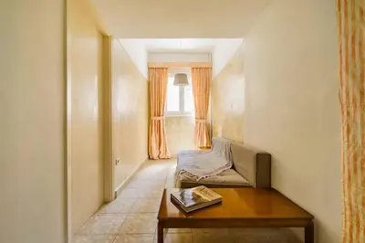 a room with a couch and a table and a window at Emporikon Apartment Steps From Historic Center in Athens