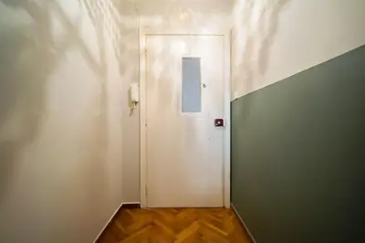 a white door with a window in a hallway at Emporikon Apartment Steps From Historic Center in Athens