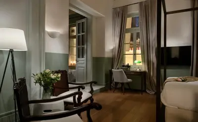 a hotel room with a bed and a desk and a window at ATHINAIDOS QUARTERS by K&K in Athens