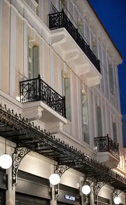 a large white building with balconies on a street at ATHINAIDOS QUARTERS by K&K in Athens