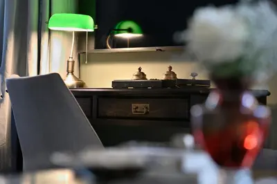 a table with a chair and a desk with a green lamp at ATHINAIDOS QUARTERS by K&K in Athens