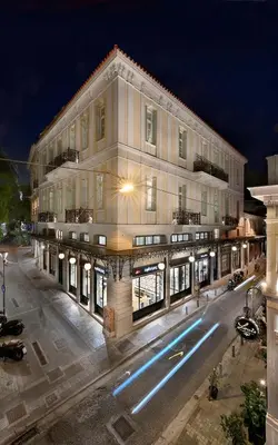 a large white building with a street at night at ATHINAIDOS QUARTERS by K&K in Athens