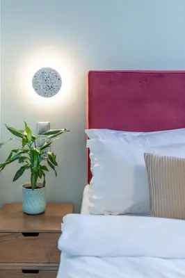 a bedroom with a bed with a plant on a night stand at TopFloor Getaway Balcony&Hot tub+Acropolis view in Athens