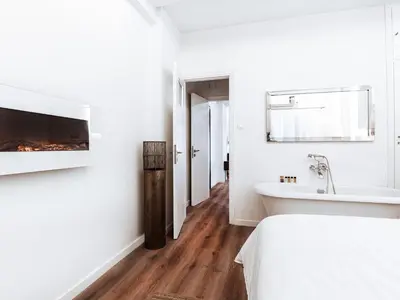 a white bedroom with a fireplace and a bed and a tub at Luxury Apartment in the Heart of the City - 1BR in Athens