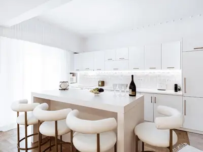 a white kitchen with white cabinets and white stools at Luxury 3BR Apartment in the Heart of the City in Athens