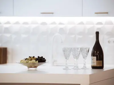 a bottle of wine and wine glasses on a counter at Luxury 3BR Apartment in the Heart of the City in Athens