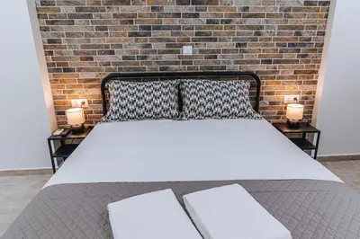 a bed in a room with a brick wall at Niovis Loft VIPGreece in Athens