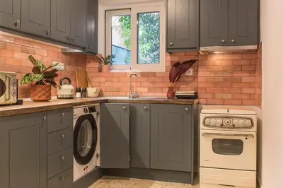 a kitchen with gray cabinets and a washer and dryer at Acropolis View-Living Stone Amethyst in Athens