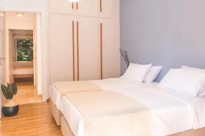 two beds in a bedroom with white walls at Acropolis View-Living Stone Amethyst in Athens