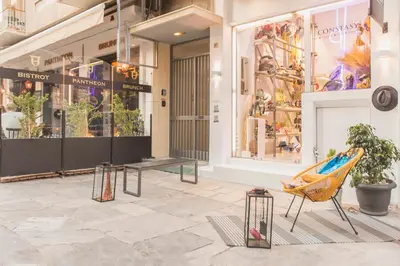 a store with a bench and a chair in front of a store at Acropolis View-Living Stone Amethyst in Athens