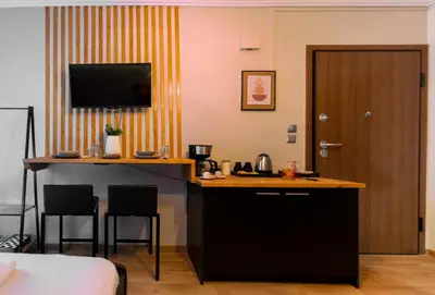 a hotel room with a kitchen and a desk with chairs at Nueva Era Boutique in Athens