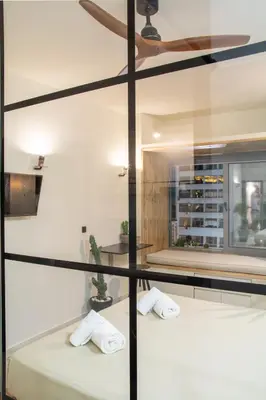 a bedroom with two beds and a glass wall at Mosaics studio apt in the Central Market of Athens in Athens