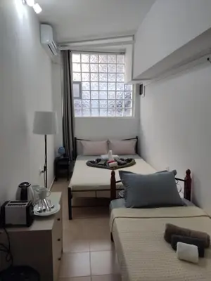 a bedroom with two beds and a window at PURE URBAN METRO KATO PATISIA in Athens
