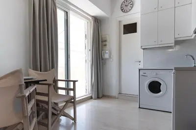 a kitchen with a washing machine and a table and chairs at Lycabetus View Loft Downtown Kolonaki in Athens